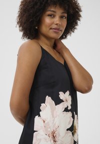 Robe sans manches noire avec de grands imprimés floraux rose clair, confectionnée en tissu lisse avec un subtil éclat. Design simple avec un décolleté en V.