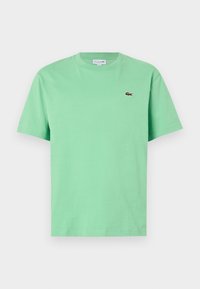 T-shirt vert clair à manches courtes et col rond avec petit logo crocodile sur la poitrine gauche.