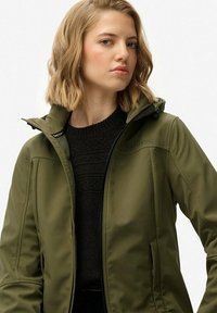 Oliwkowa kurtka zapinana na zamek, z wysokim kołnierzem i kapturem. Gładki, wodoodporny materiał. Posiada boczne kieszenie oraz subtelne logo na piersi.