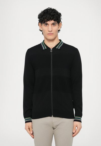 Black zip-up cardigan with a striped collar featuring green, purple, and white accents. Smooth texture, long sleeves, and a relaxed fit.