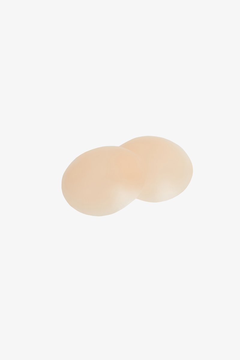 Beżowe silikonowe formy piersi o gładkiej fakturze, owalnym kształcie i subtelnym połysku, zaprojektowane dla naturalnego dopasowania. Dwa elementy umieszczone blisko siebie.