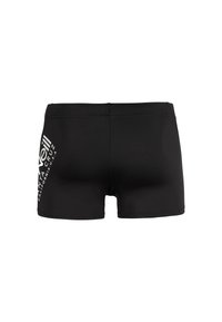 Shorts de bain noirs en tissu extensible, avec un logo graphique blanc sur le côté gauche et un design lisse et sans couture.