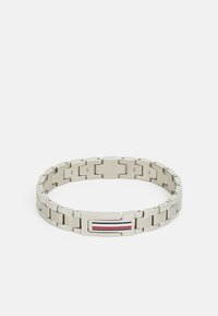 Pulsera de metal plateado con eslabones entrelazados, que presenta un cierre plano y rectangular y un diseño rayado de acentos en rojo, blanco y azul.