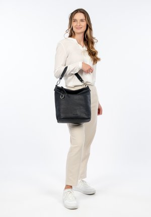 Black leather bucket bag with a textured finish, adjustable strap, silver hardware, and a circular accent detail.