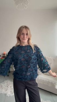 Mørk teal top lavet af gennemsigtigt stof med lagdelte fjer-lignende mønstre, løs pasform, trekvartærmer kombineret med sorte bukser.