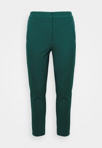 Green tapered trousers made of smooth fabric, featuring two front pockets with small silver buttons. Available in a sleek, tailored design.