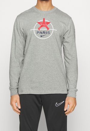 T-shirt gris à manches longues avec un motif de la Tour Eiffel et "PARIS" en bleu, entouré d'un liseré blanc, avec le logo Nike.