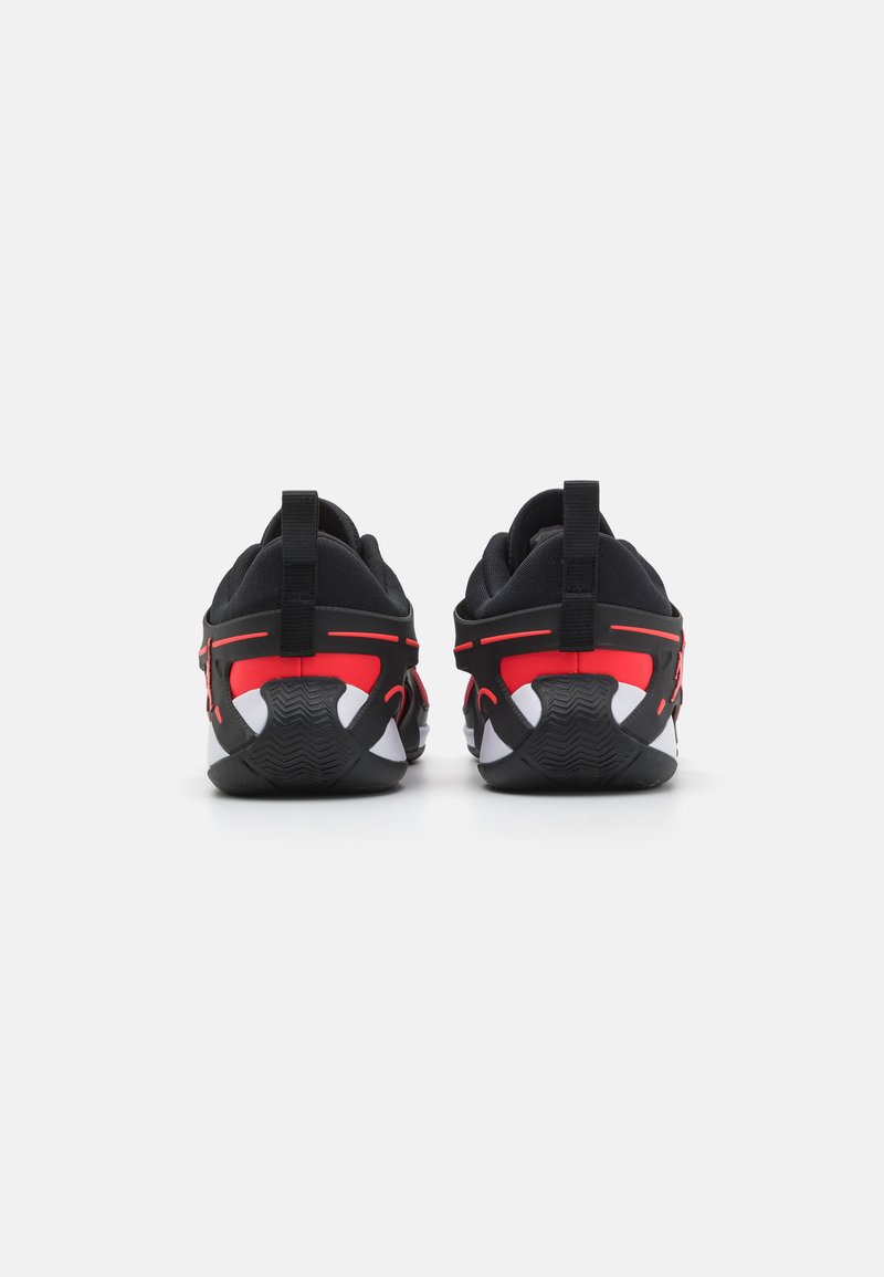 Schwarze Laufschuhe mit roten Akzenten und weißen Sohlen. Sie verfügen über ein strukturiertes schwarzes Obermaterial, Zuglaschen und ein ausgeprägtes Profilmuster.