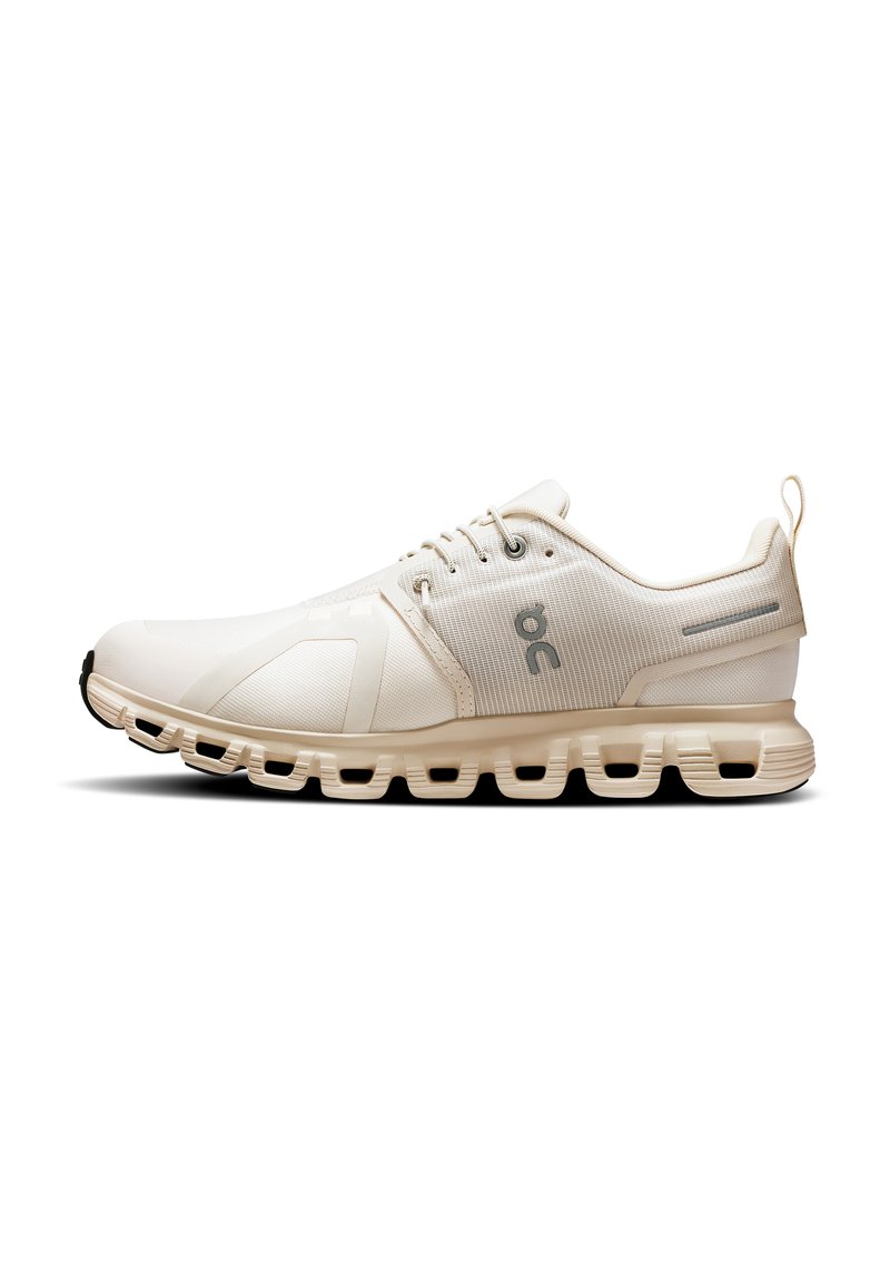 Chaussure de sport beige clair avec tige en maille, design minimaliste, bout rond et semelle rembourrée avec des découpes segmentées pour plus de flexibilité.