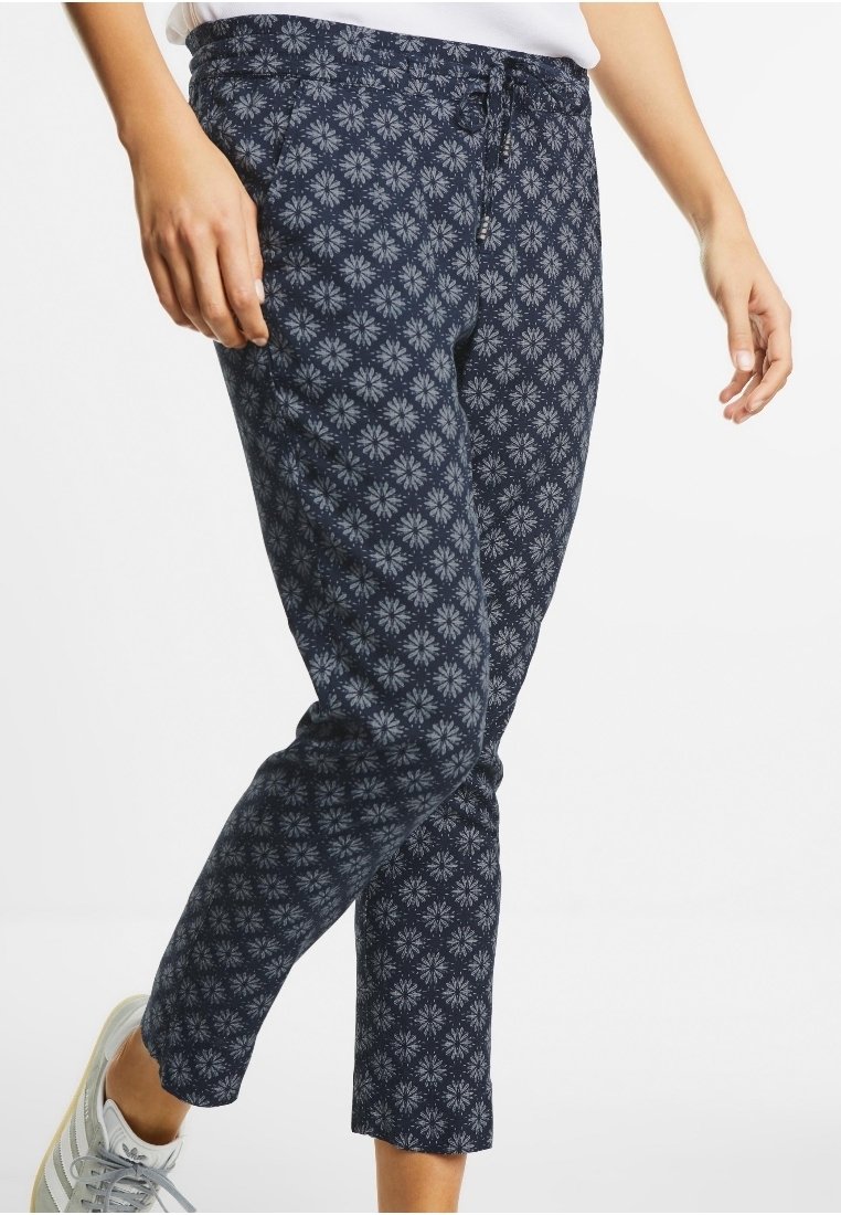 Námořnické modré kalhoty s květinovým vzorem ve světle modré barvě, s elastickým pasem a slim fit střihem, který se zúžuje na kotnících.