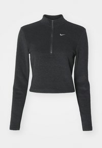 Czarny, krótki sweatshirt Nike z wysokim kołnierzem, długimi rękawami i zamkiem błyskawicznym z przodu. Posiada małe, białe logo Nike na klatce piersiowej. Miękka tekstura.