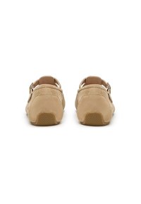 Beige Wildlederschuhe mit einem Rückenriemen, ausgestattet mit einem kleinen Absatz und einer strukturierten Gummisohle. Metalldetail mit Schnalle an der Seite.