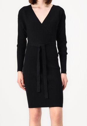 Schwarzes, geripptes Strickkleid mit tiefem V-Ausschnitt, langen Ärmeln und einem Bindegürtel in der Taille. Der Stoff hat eine strukturierte Oberfläche.