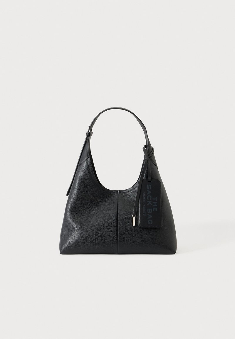 Sac à bandoulière en cuir noir avec une poignée supérieure courbée et une étiquette portant la mention "The Sack Bag Marc Jacobs" sur un fond clair.