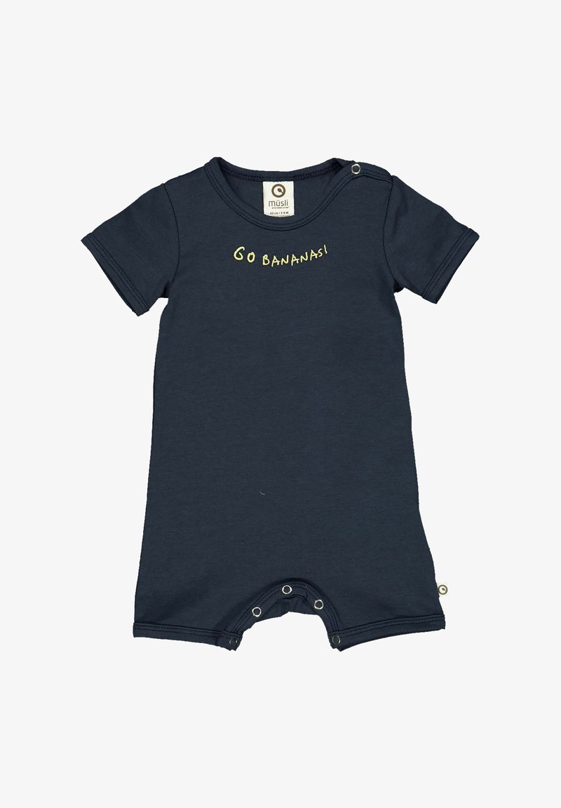 Námořnická modrá bavlněná kombinéza s krátkým rukávem, s žlutým nápisem "JDI BANÁNY!" poblíž výstřihu a niklovými patentními knoflíky na spodní části.