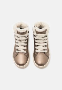 Zapatillas altas metálicas bronce con forro de piel blanca, cordones blancos y suela de goma beige. Presenta punta redondeada y superficie texturizada.