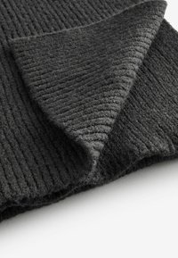 Dunkelgrauer, gerippter Stoff mit einer sanften Textur, der eine gefaltete Kante und subtile Variationen im Strickmuster aufweist. Ideal für warme Kleidungsstücke.