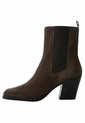 Brown suede ankle boot with elastic side panels, pointed toe, and chunky black heel. Features pull tab at rear for easy wear.