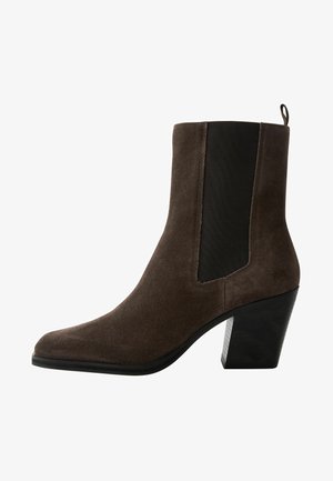 Brown suede ankle boot with elastic side panels, pointed toe, and chunky black heel. Features pull tab at rear for easy wear.