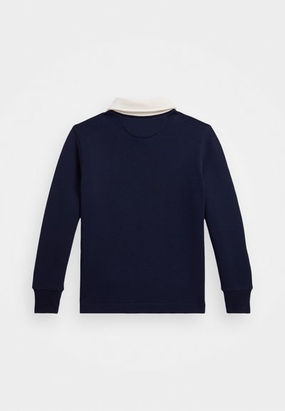 Camisa polo de manga larga en navy con cuello crema, material de algodón, puños acanalados y un diseño simple y limpio. Presenta una costura en la parte trasera del cuello.