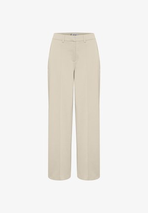 Beežid laiad püksid siledast kangast, millel on ees voldid, tavaline vöökoht ning nähtamatud taskud ja kaunistused.