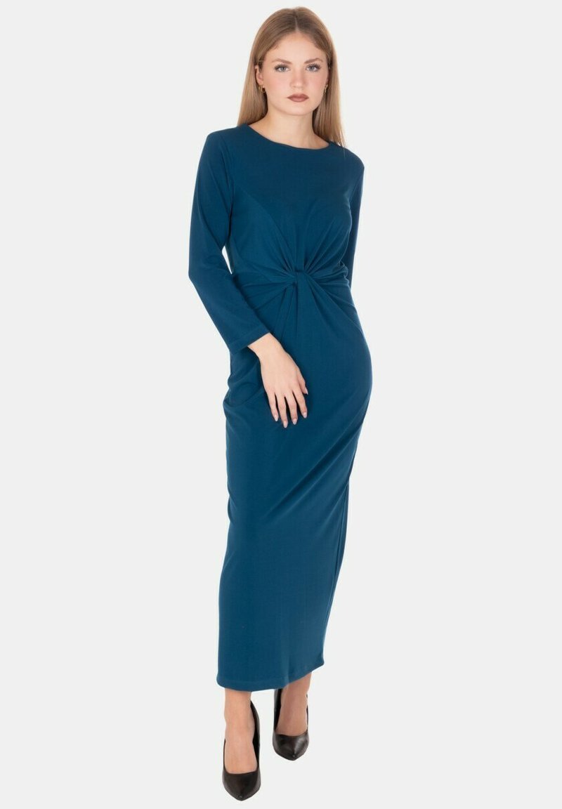 Vestito a maniche lunghe di colore teal realizzato in tessuto liscio. Presenta un dettaglio arricciato in vita, una silhouette aderente e un orlo lungo fino al pavimento.