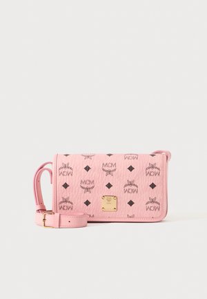 Sac bandoulière en cuir rose avec logos MCM noirs et plaque de marque en métal doré, doté d'une bandoulière réglable et d'une texture grainée.