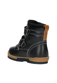Stivale alla caviglia per bambini in pelle nera con suola marrone, cuciture bianche, due cinturini in Velcro e morbida fodera interna nera.