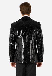 Blazer nero in paillettes con una superficie lucida e strutturata. Presenta un design classico da smoking con rever a punta e chiusura a un bottone.