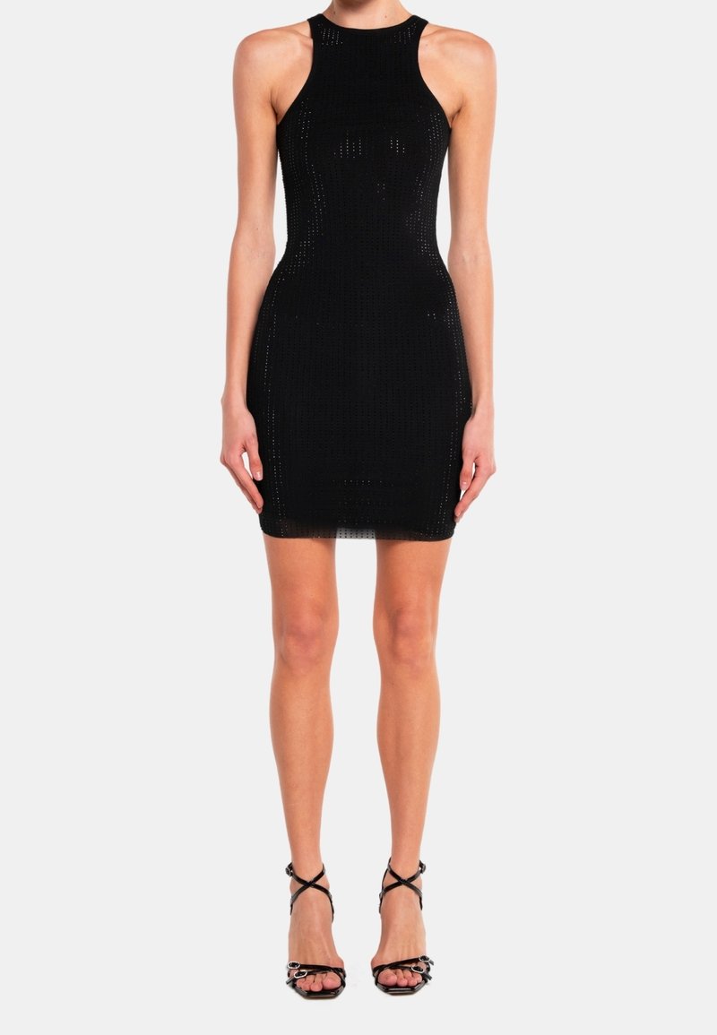 Robe mini sans manches noire avec une silhouette ajustée, en tissu texturé et un col rond. Associée à des sandales à talons noires à lanières.