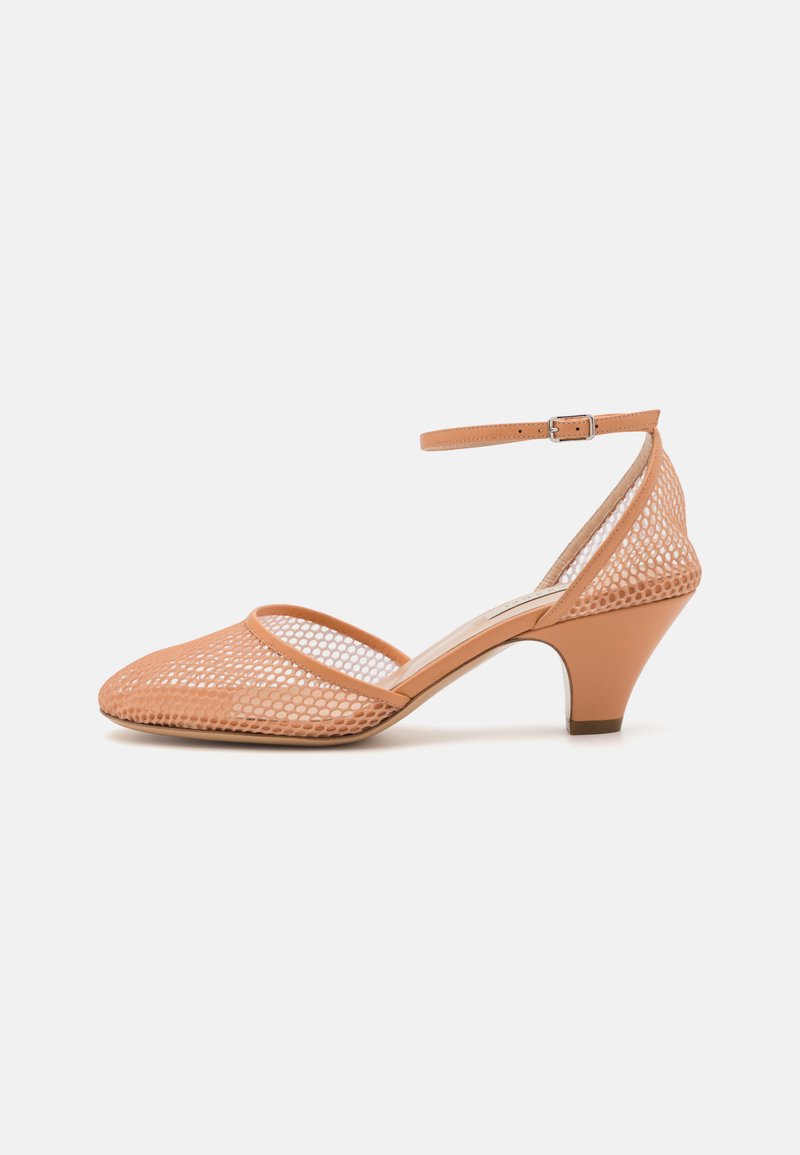 Escarpin en mesh pêche à bout ouvert, avec une large sangle et une boucle à la cheville. Le talon en forme de cône mesure 6,5 cm de haut et possède une finition lisse.