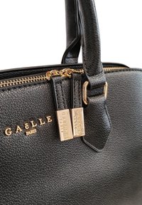 Borsa handbag in pelle nera testurizzata con accessori dorati, dotata di doppi zip e logo del marchio impresso sul davanti.