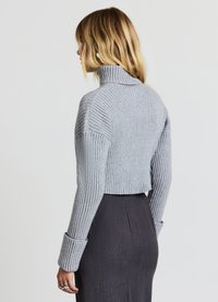 Kurzes graues, geripptes Turtleneck-Pullover mit langen, engen Ärmeln und einer strukturierten Oberfläche. Glattes Material und entspannter Schnitt.