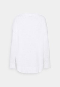 Maglione bianco lavorato a maglia con una vestibilità ampia, scollatura larga e orlo e polsini a coste. Il tessuto testurizzato crea un aspetto morbido e accogliente.