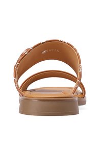 Sandali flat marroni con due ampie cinghie, dotati di una suola imbottita e un logo discreto sul lato interno. Finitura testurizzata sulle cinghie.