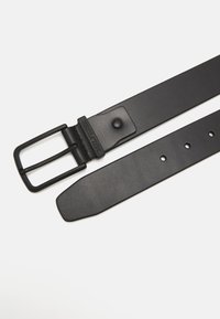 Cintura in pelle nera con una fibbia metallica rettangolare. Presenta una superficie liscia, più fori per la regolazione e un logo decorativo vicino alla fibbia.