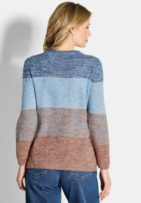 Maglione a maglia con un design gradient nei toni del blu e del marrone, con maniche lunghe e una vestibilità rilassata. Superficie tessurizzata con una delicata trama.