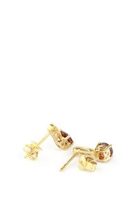 Orecchini in oro con gemme ovali marroni incastonate in metallo lavorato ad intricate decorazioni di filigrana, dotati di chiodini e farfalline visibili.