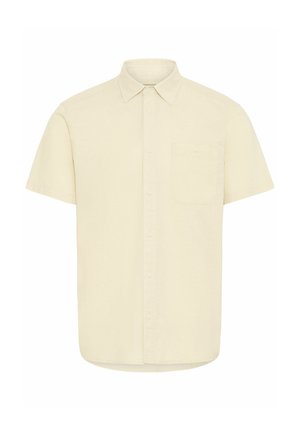 Chemise à manches courtes de couleur beige clair en coton, avec un col pointu, une poche avant et une fermeture à boutons, texture de tissu lisse.
