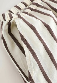 Katoenen korte broek met verticale bruine en crèmekleurige strepen, voorzien van een elastische tailleband en gestructureerde stof voor een comfortabele pasvorm.