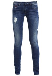 Pantalones vaqueros ajustados de mezclilla en lavado azul oscuro con detalles desgastados, incluyendo roturas y decoloración, cintura estándar y diseño de cinco bolsillos.