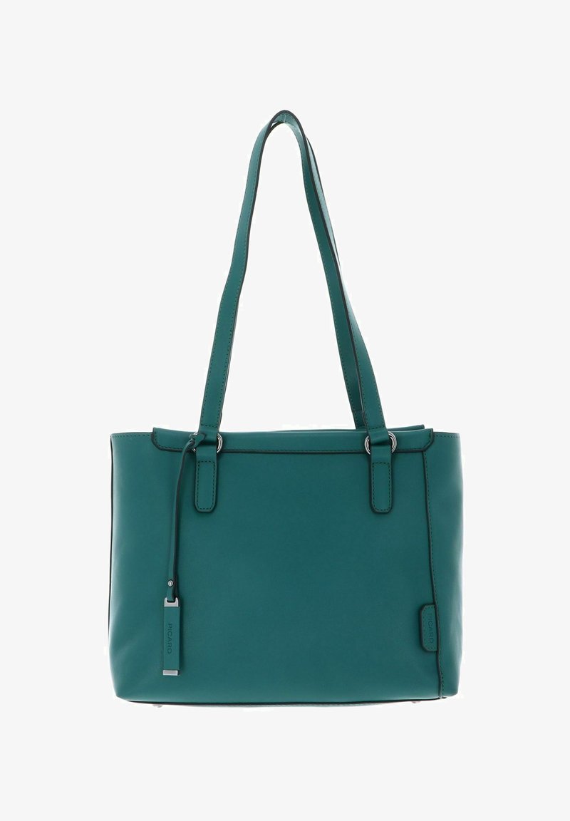 Sac à bandoulière en cuir bleu sarcelle avec deux anses, coutures minimales et une petite étiquette rectangulaire suspendue à une des anses.