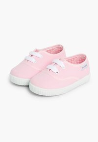 Sneaker di tela rosa chiaro con lacci bianchi, suole in gomma texturizzata e una fodera a quadretti. Presentano dettagli cuciti e un accento con logo.