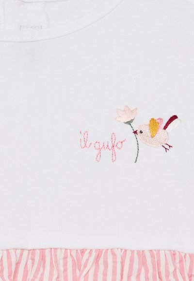 Hvit bomullstop med broderte fugler og blomsterdesign. Den nedre delen har en rosa stripete volangdetalj. Teksten sier "il gufo."