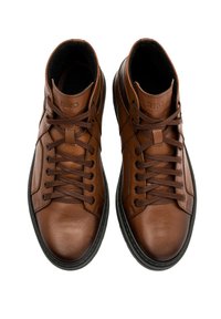 Brązowe skórzane sneakersy typu high-top z czarną gumową podeszwą, okrągłymi noskami, kontrastującymi sznurowadłami oraz wytłoczonym logotypem na języku.