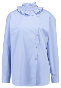 Camicia azzurro chiaro con colletto arricciato, maniche lunghe e una vestibilità leggermente ampia. Presenta bottoni metallici sul davanti.
