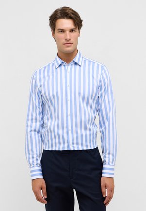 Chemise boutonnée rayée bleu clair et blanche avec un col standard. Dotée de manches longues et de poignets rayés contrastants. Texture de tissu lisse.