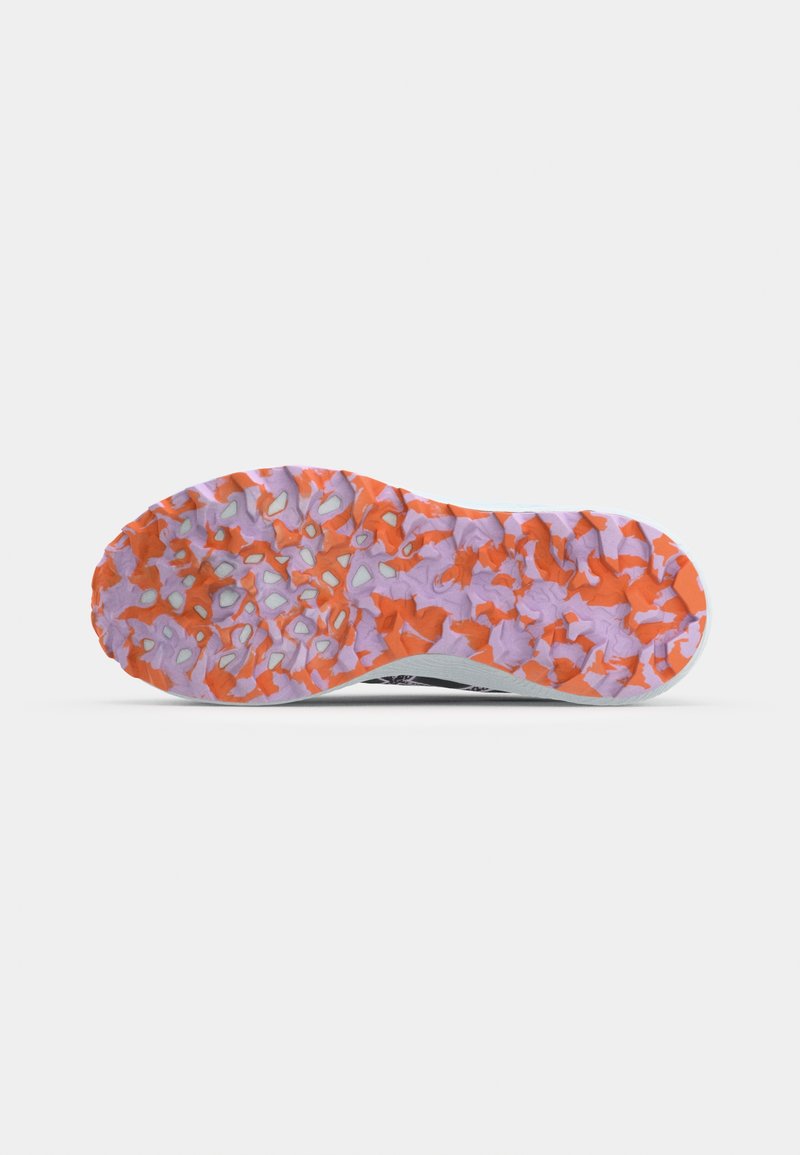 Zapatillas con suela de goma texturizada en naranja y púrpura, con un diseño de múltiples patrones, parte superior blanca y acentos negros.