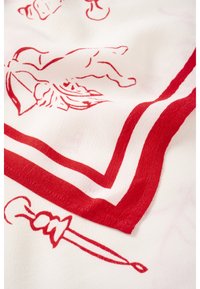 Tissu blanc avec bordure rouge et illustrations en ligne rouge représentant une personne et une épée, détail dans le coin du textile.