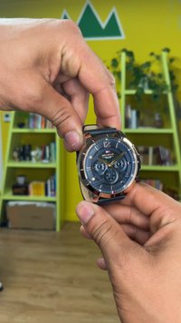 Schwarze und roségoldene Armbanduhr mit rundem Zifferblatt, strukturiertem Ziffernblatt, drei Unterzifferblättern und einem Lederarmband, Zeiger in Gold zeigen die Zeit an.